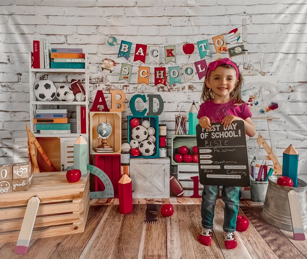 Back to school themed photo setup with alphabet decorations, books, and colorful accessories.