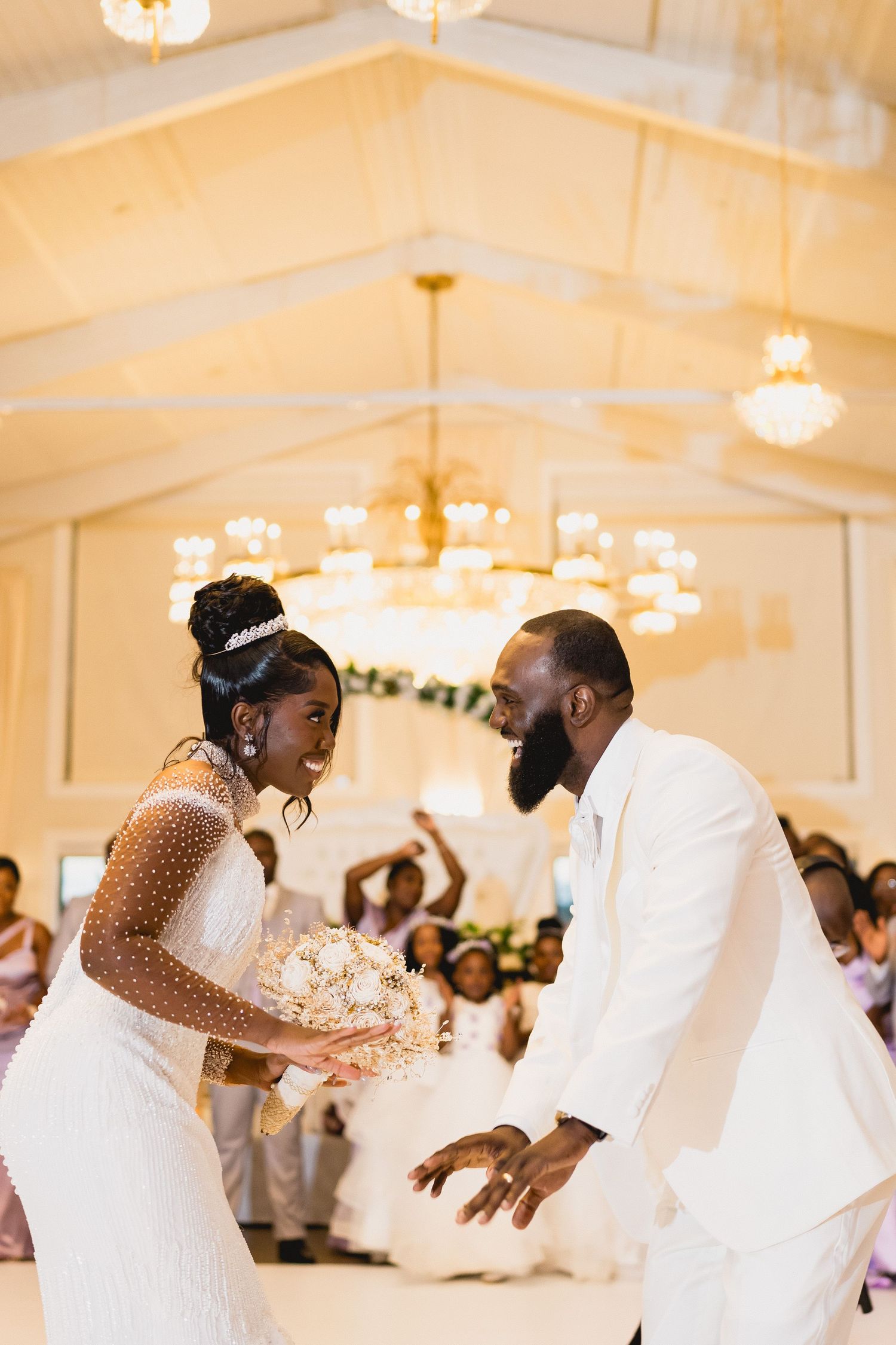 Energetic couple dancing at their wedding reception under crystal chandeliers.