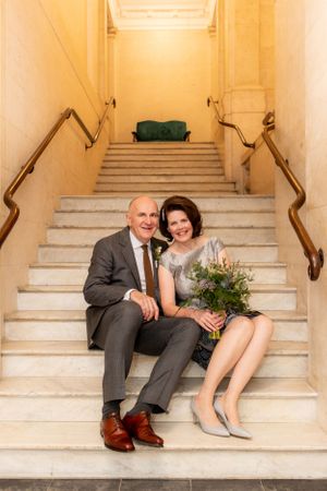 Bride and Groom sit on the stairs of the registry office after their wedding ceremony - Wedding Photography