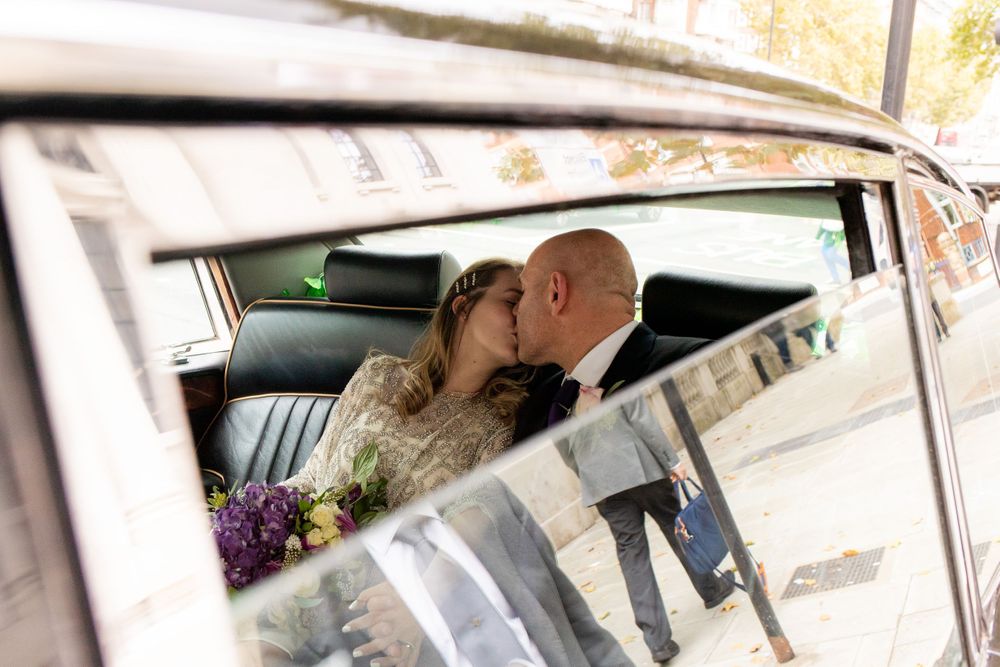 Bride and Groom share a secret kiss in the wedding car - Wedding Photography
