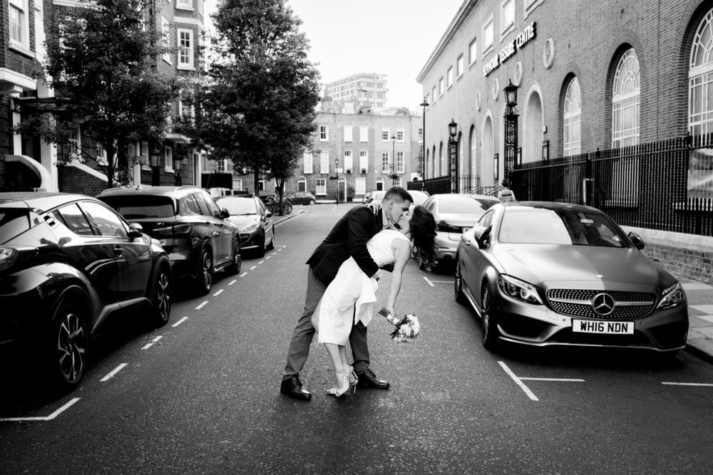 Bride and groom kiss in a London street - Wedding Photography by Claire Jonas Photography