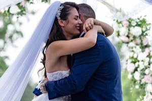 Intimate embrace shared during outdoor wedding ceremony.