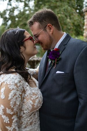 A tender moment between newlyweds sharing laughter and an intimate moment in a garden.