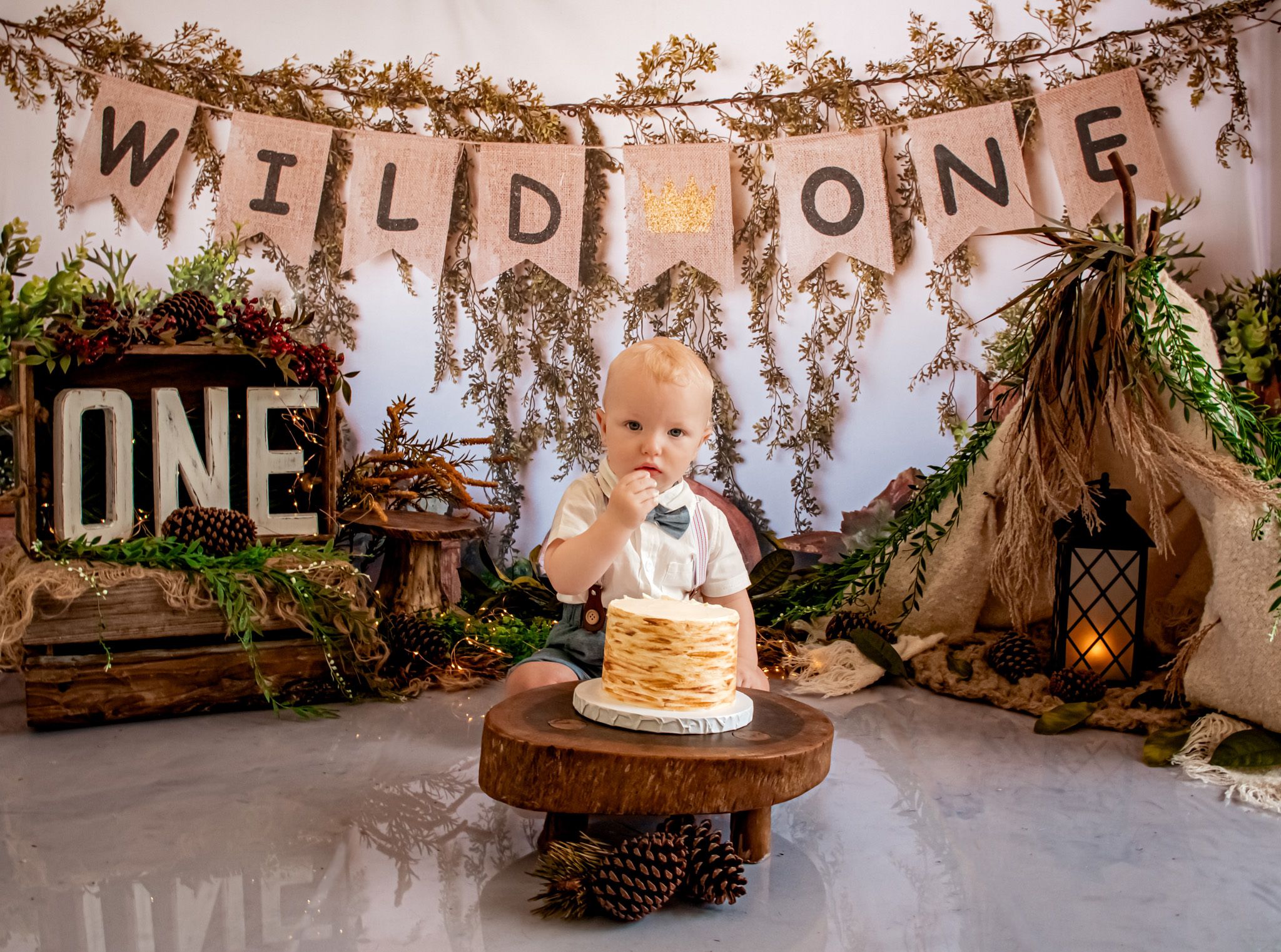 A rustic 'Wild One' themed first birthday setup with woodland decorations and natural elements.