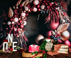 Dark moody party setup with red ornaments, feathers, and decorative elements.
