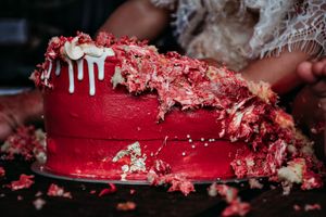 Smashed red birthday cake showing destroyed layers and frosting.