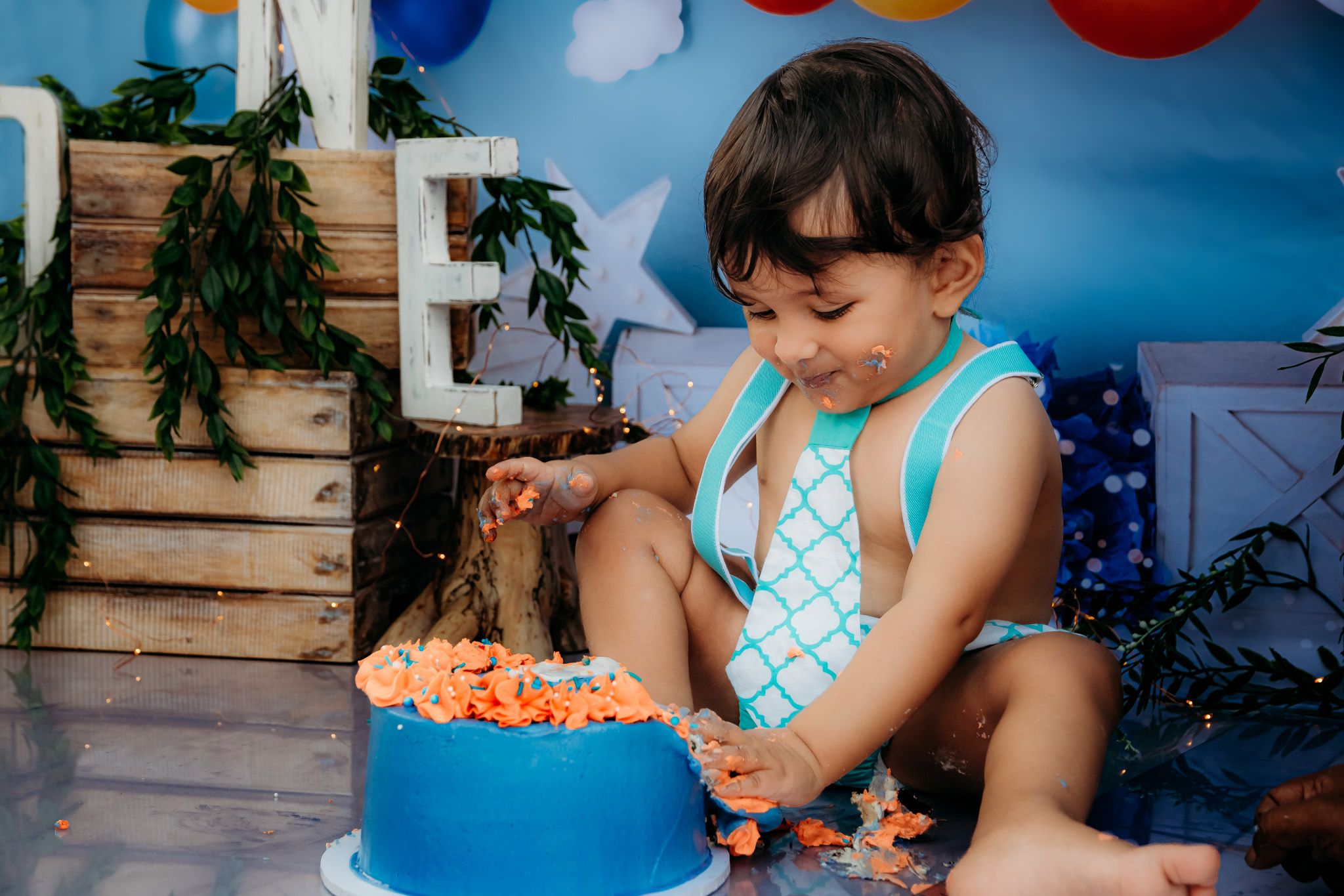 Child's birthday party decorations with colorful balloons and wooden accents.