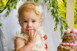 Sweet cake smash photography session with floral decorations and natural lighting.