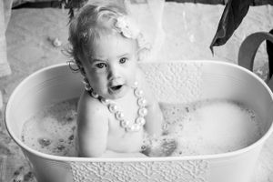 Classic black and white bath time photo series with bubbles and vintage-style tub.
