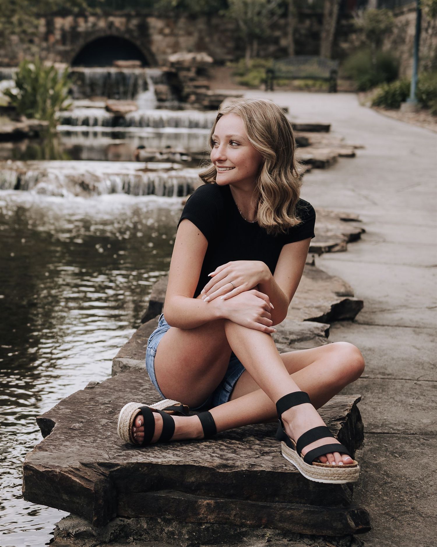 A casual summer portrait session by a landscaped waterfall.