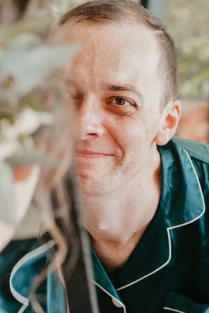 Portrait of a person in a green jacket with a gentle smile.