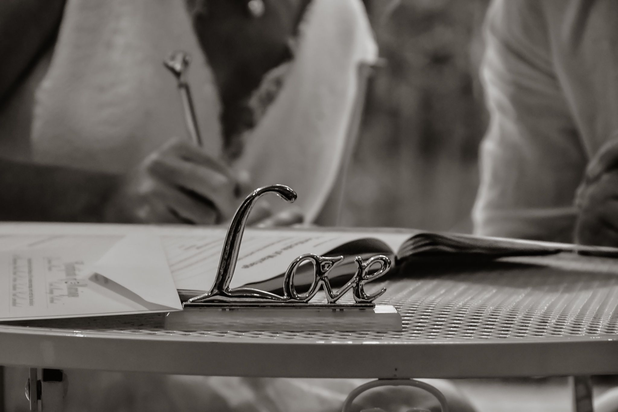 Wedding documents and glasses on a table during a signing ceremony.