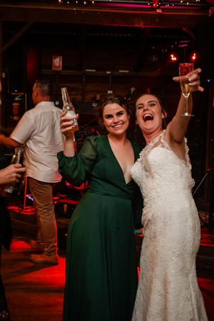 Wedding celebration in a dimly lit venue with red lighting and festive atmosphere.