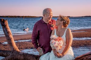A couple sharing a romantic moment on a beach at sunset.