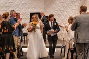 Wedding ceremony celebration in modern venue with textured white wall.