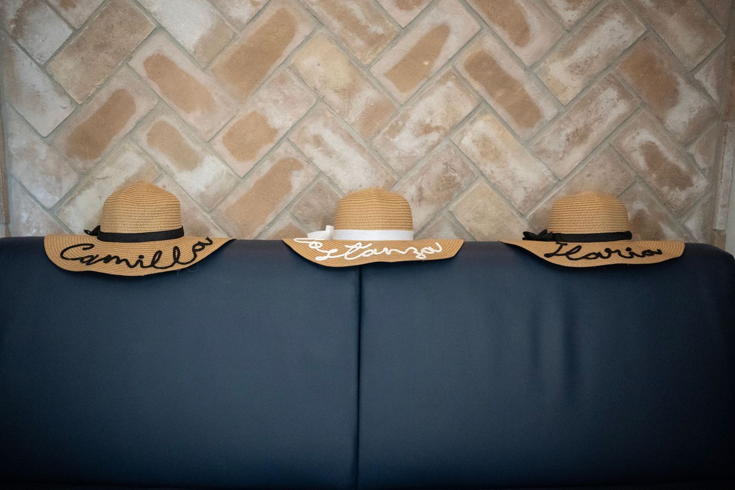 Three beige cowboy hats displayed in a row against a dark blue backdrop.