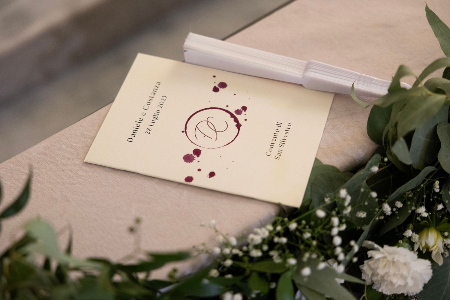 Wedding invitation with decorative monogram design and floral elements.