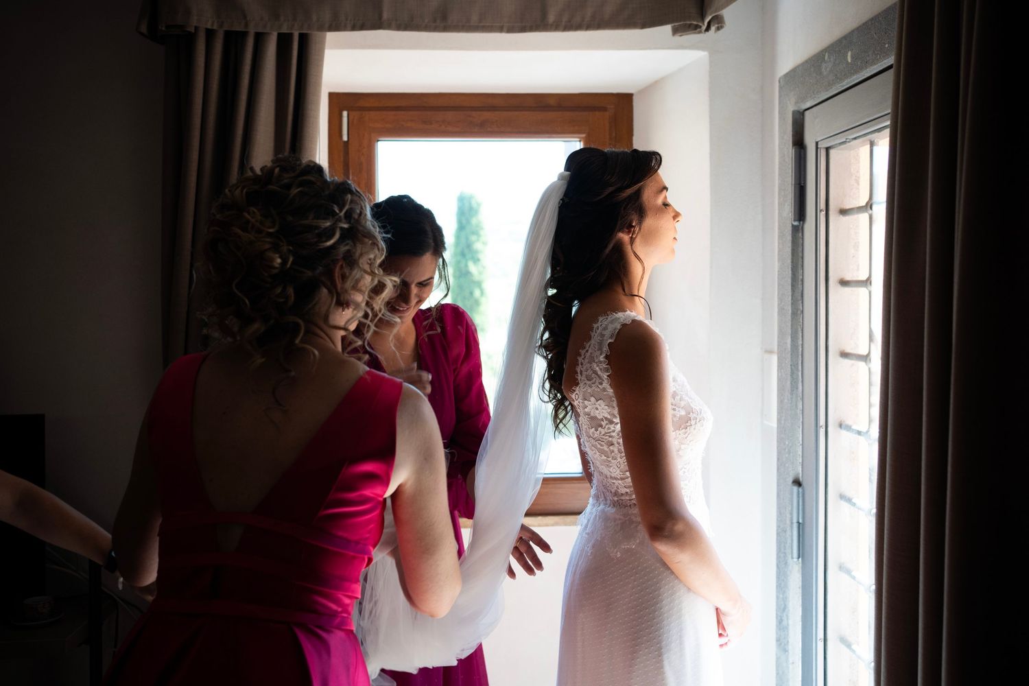 Wedding preparation scene with soft natural light streaming through window.