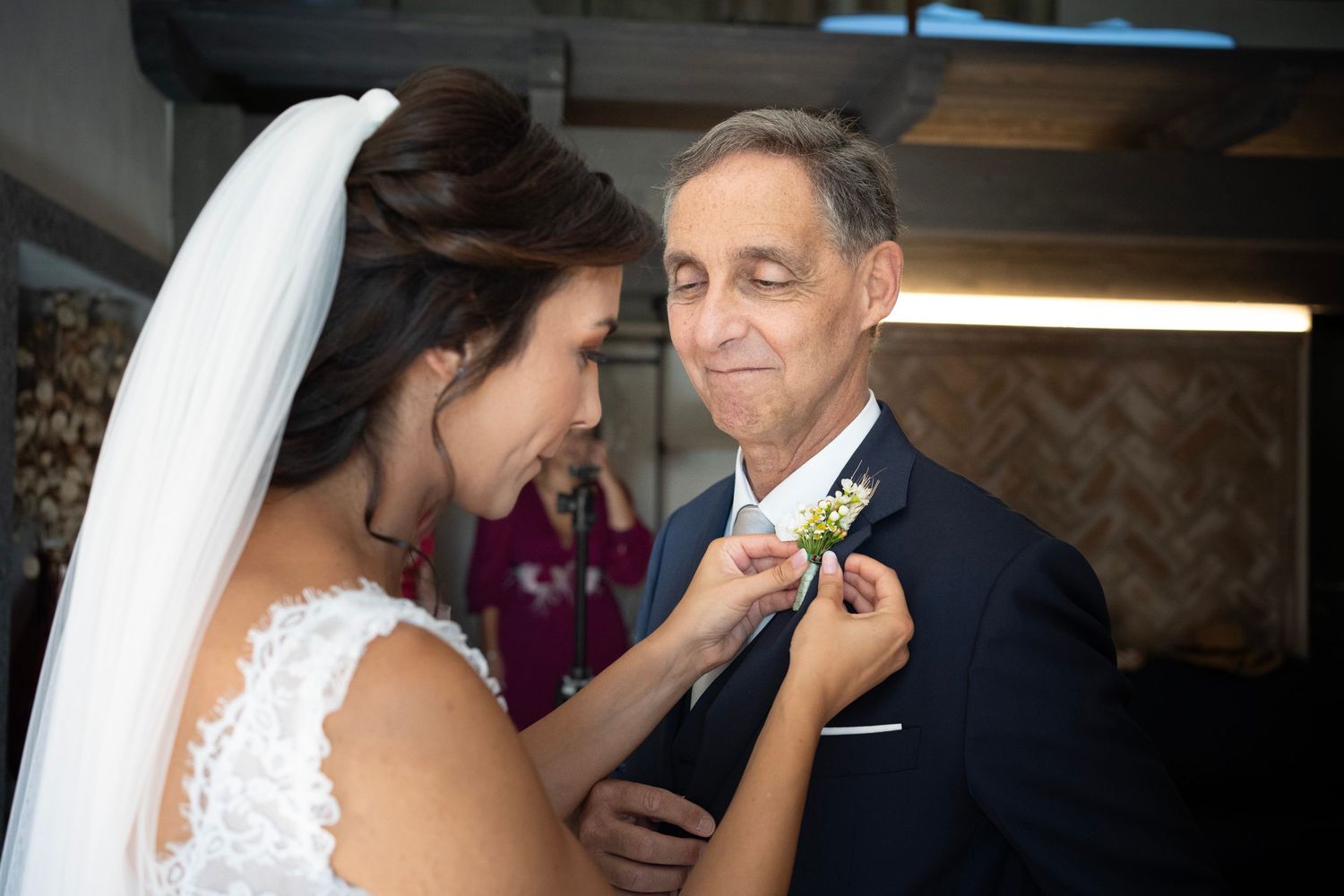 A sweet interaction during wedding preparations as a boutonniere is pinned on.