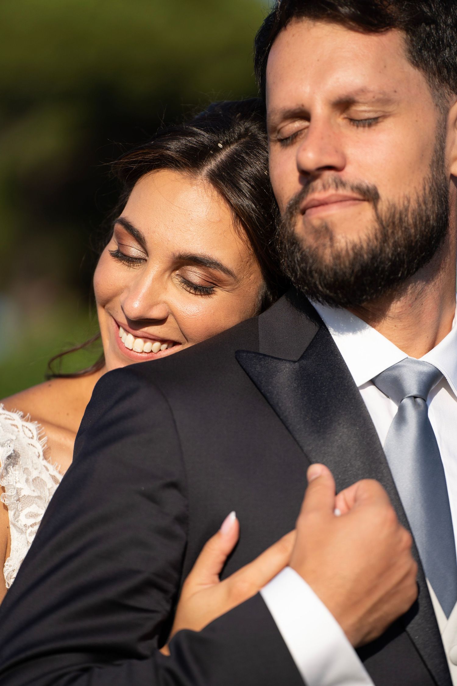 An intimate embrace between newlyweds captured in warm sunlight.