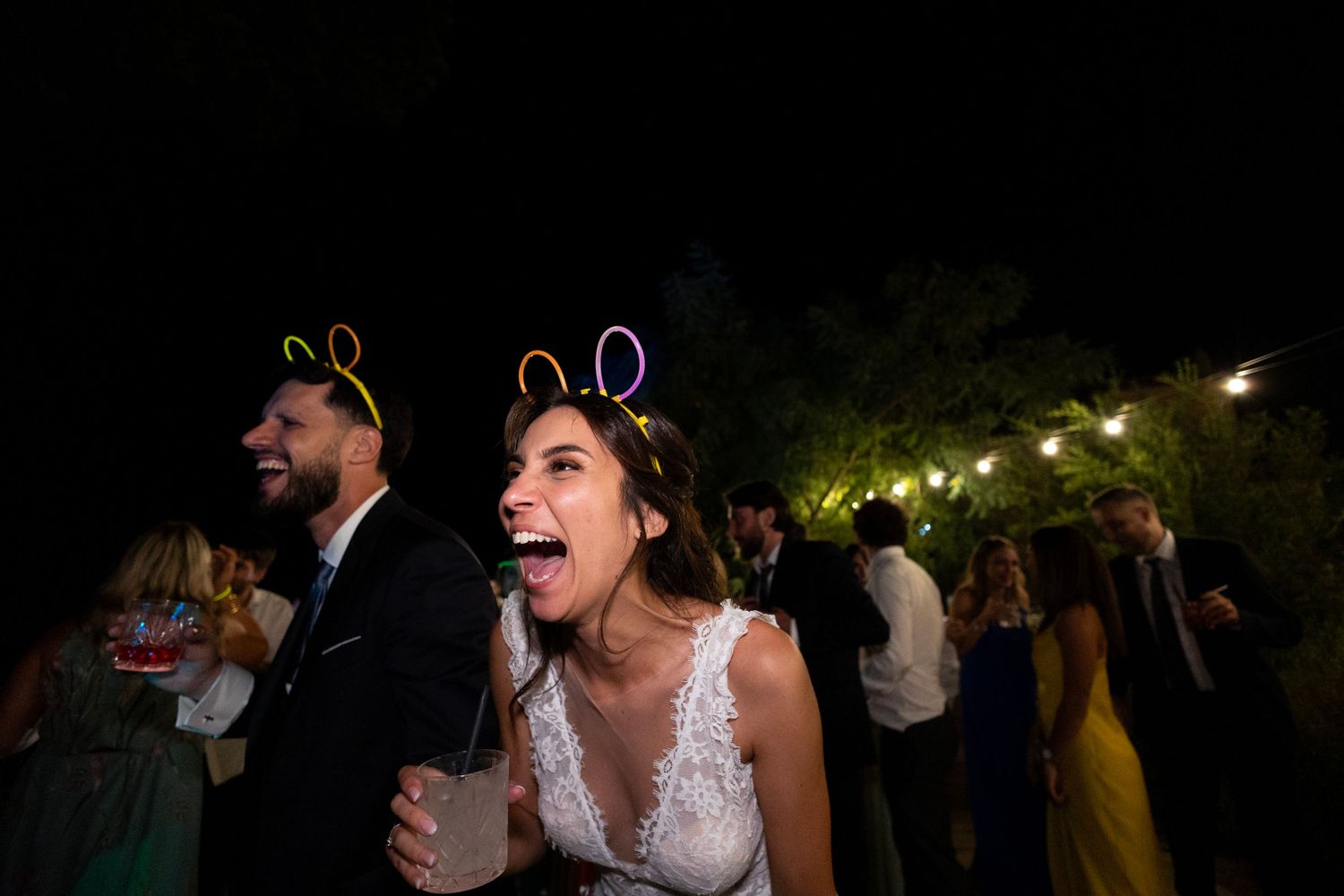 Wedding celebration at night with guests wearing festive light-up bunny ears.