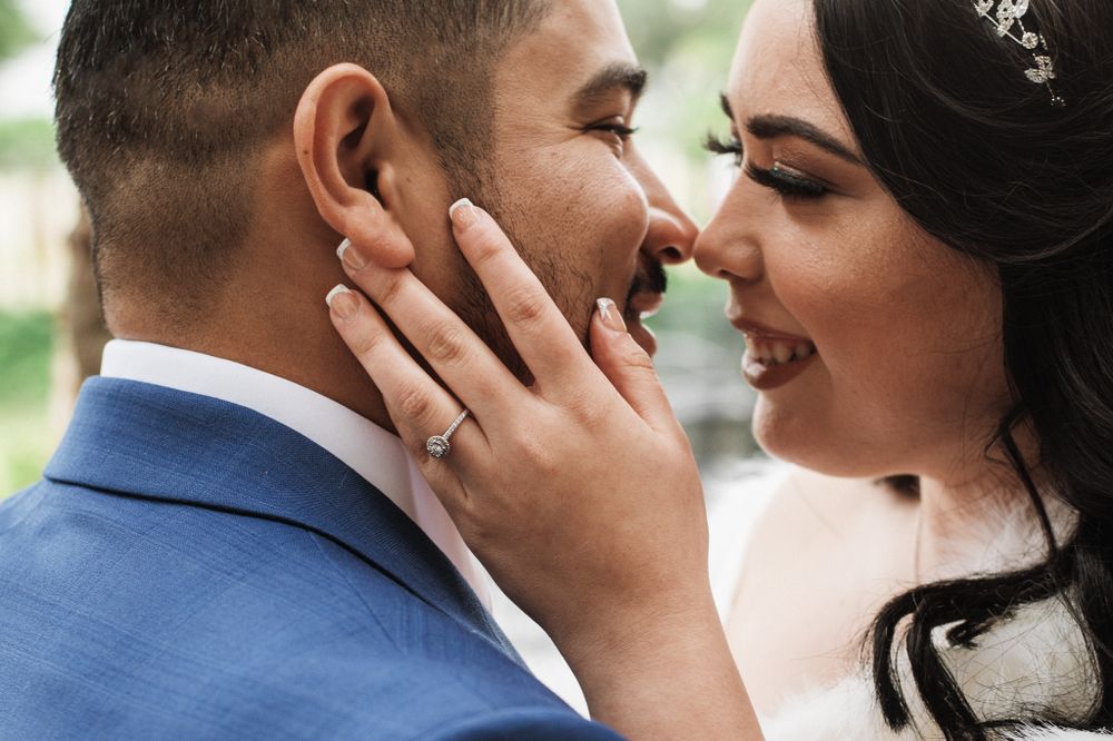 Intimate close-up of newlyweds sharing a tender moment outdoors.