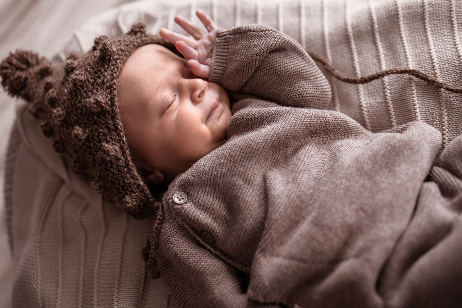 Zachte pastelkleuren tijdens newborn lifestyle shoot in slaapkamer. Minimalistische newbornfoto met focus op zachtheid en rust.