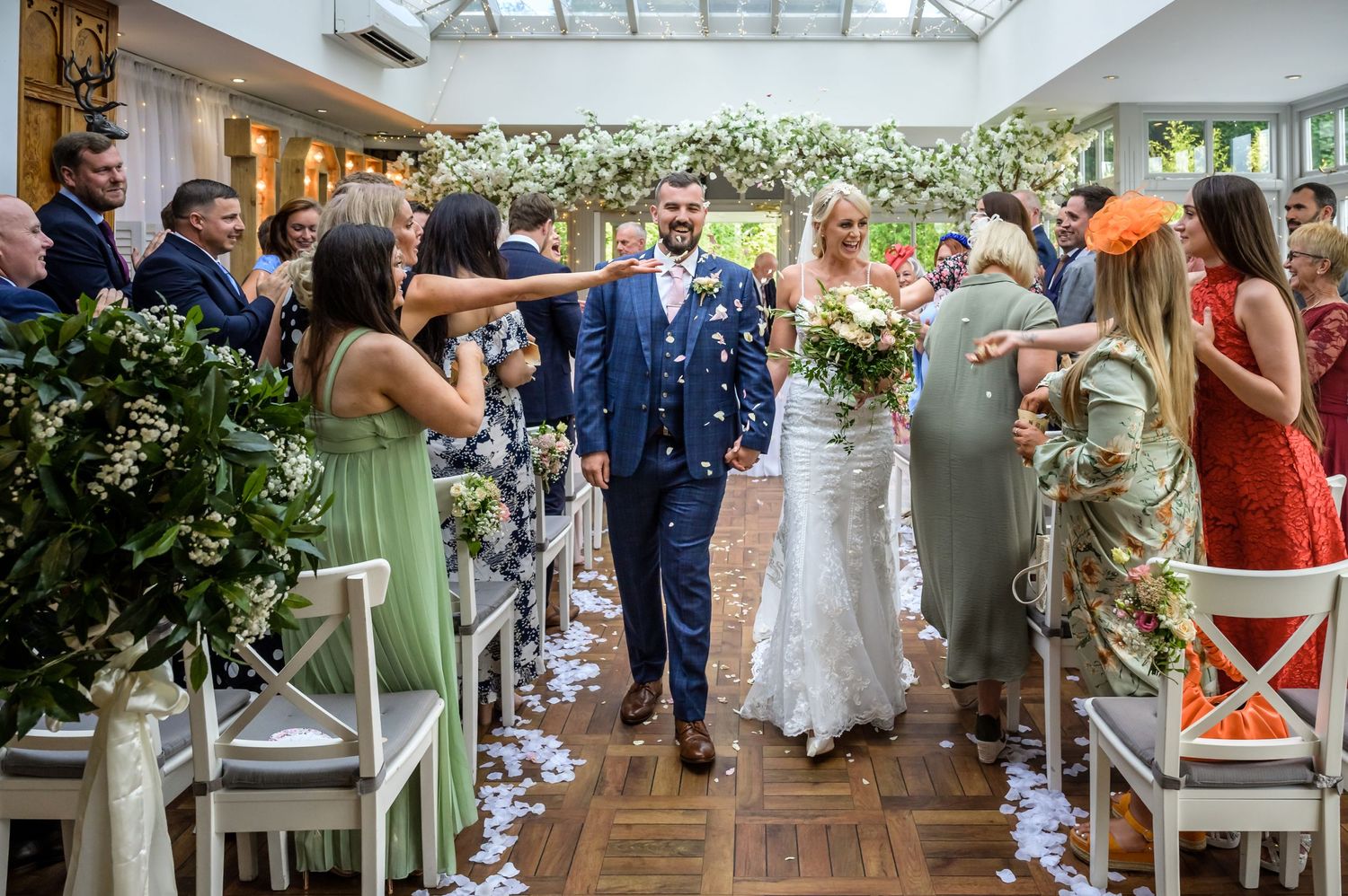 Bride and groom showered with confetti as they exit after their wedding ceremony at Broadoaks Country House Hotel