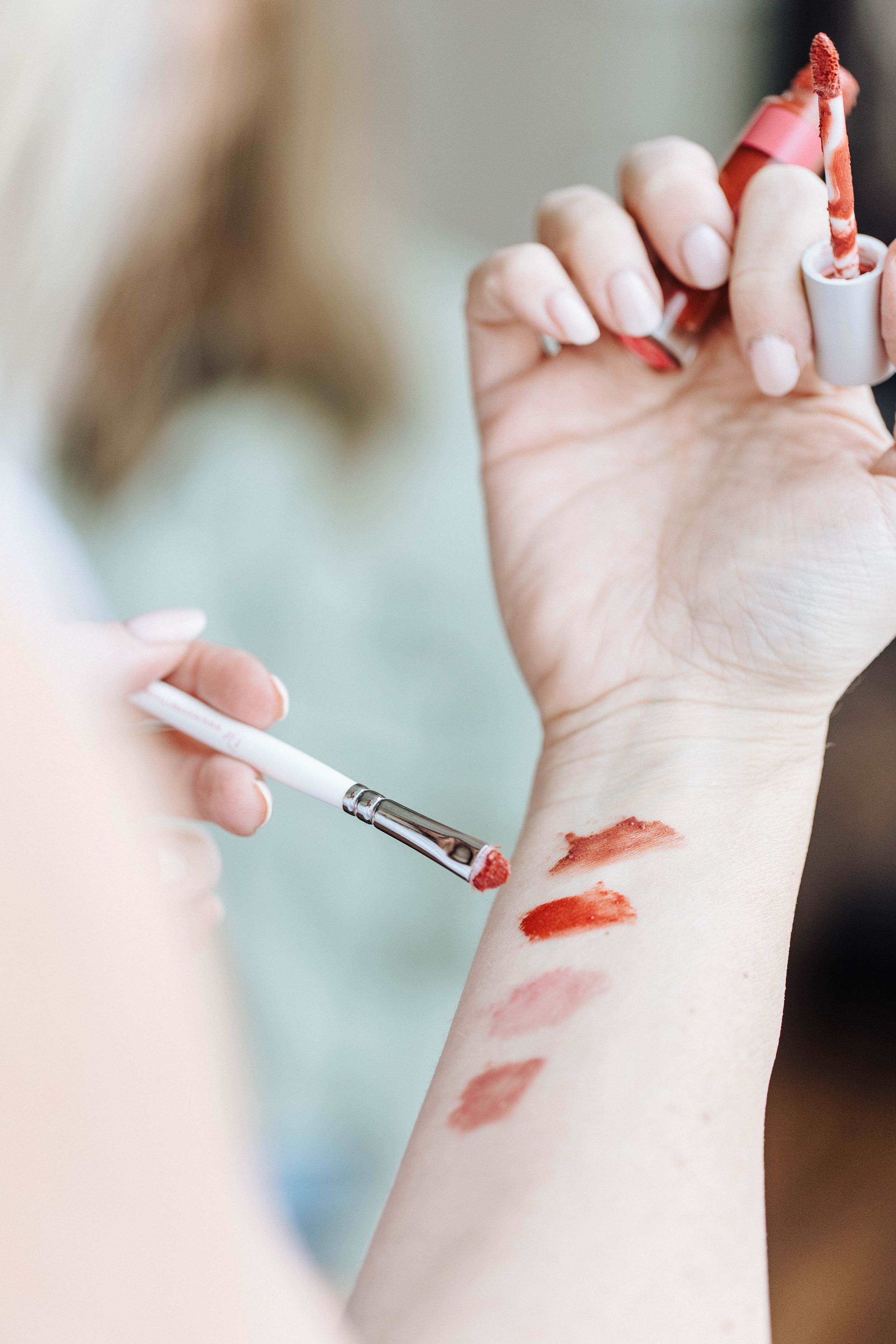 Lipstick swatches being tested on someone's inner arm.