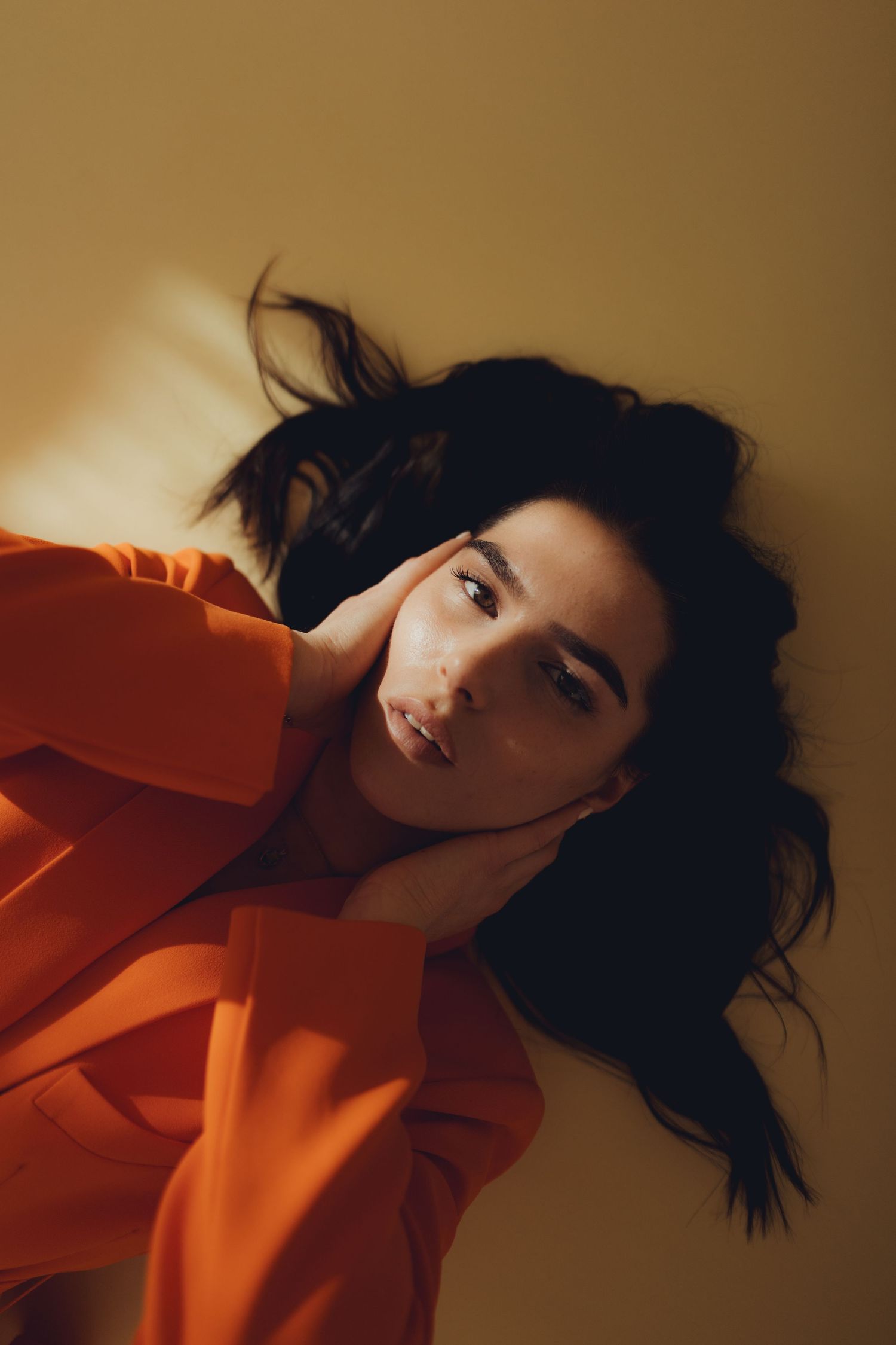Porträtfoto einer Frau in einem orangenen Blazer