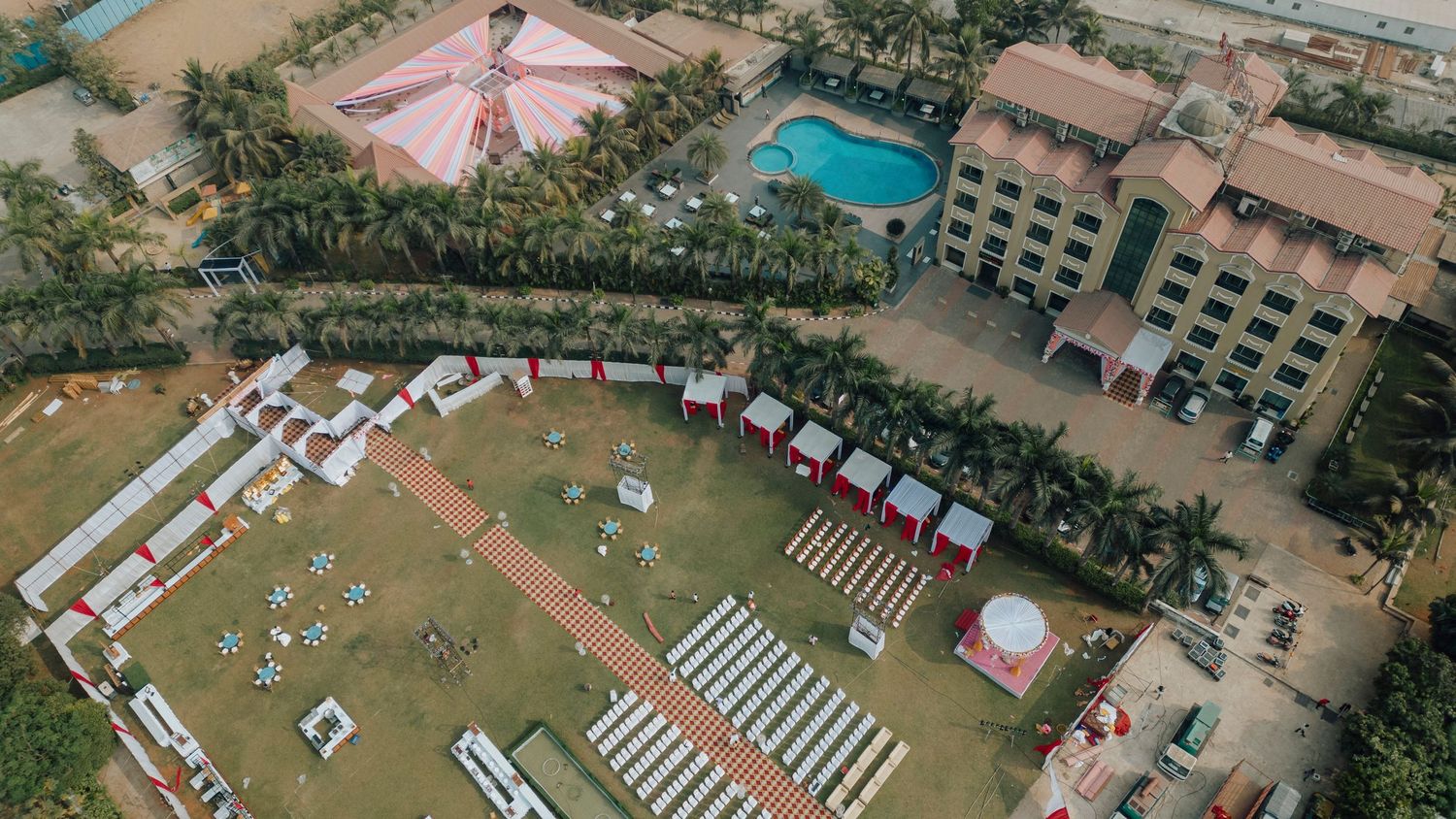 Aerial view of a luxury resort venue with swimming pools and manicured grounds.