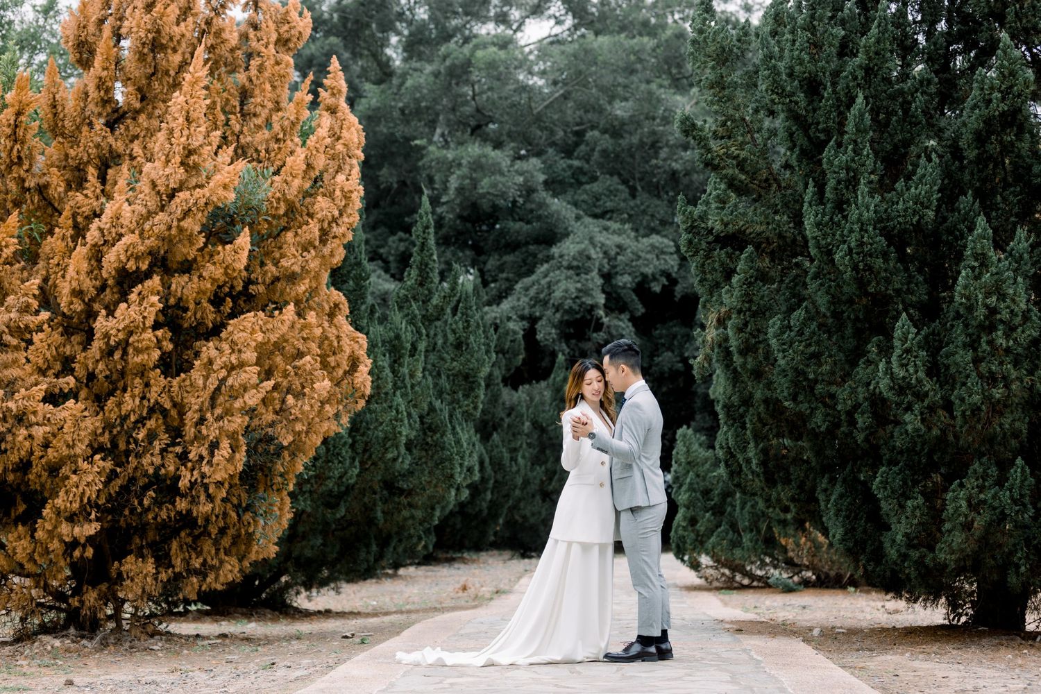 Dreamy garden wedding photography with natural pathway and autumn colored trees.