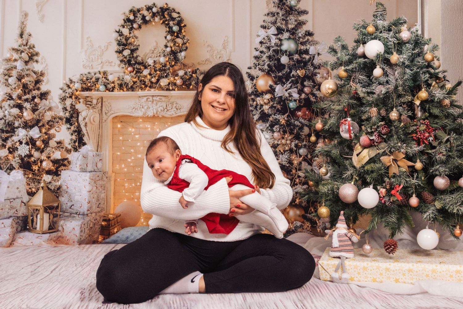 Holiday portrait in front of decorated Christmas trees with festive decor.
