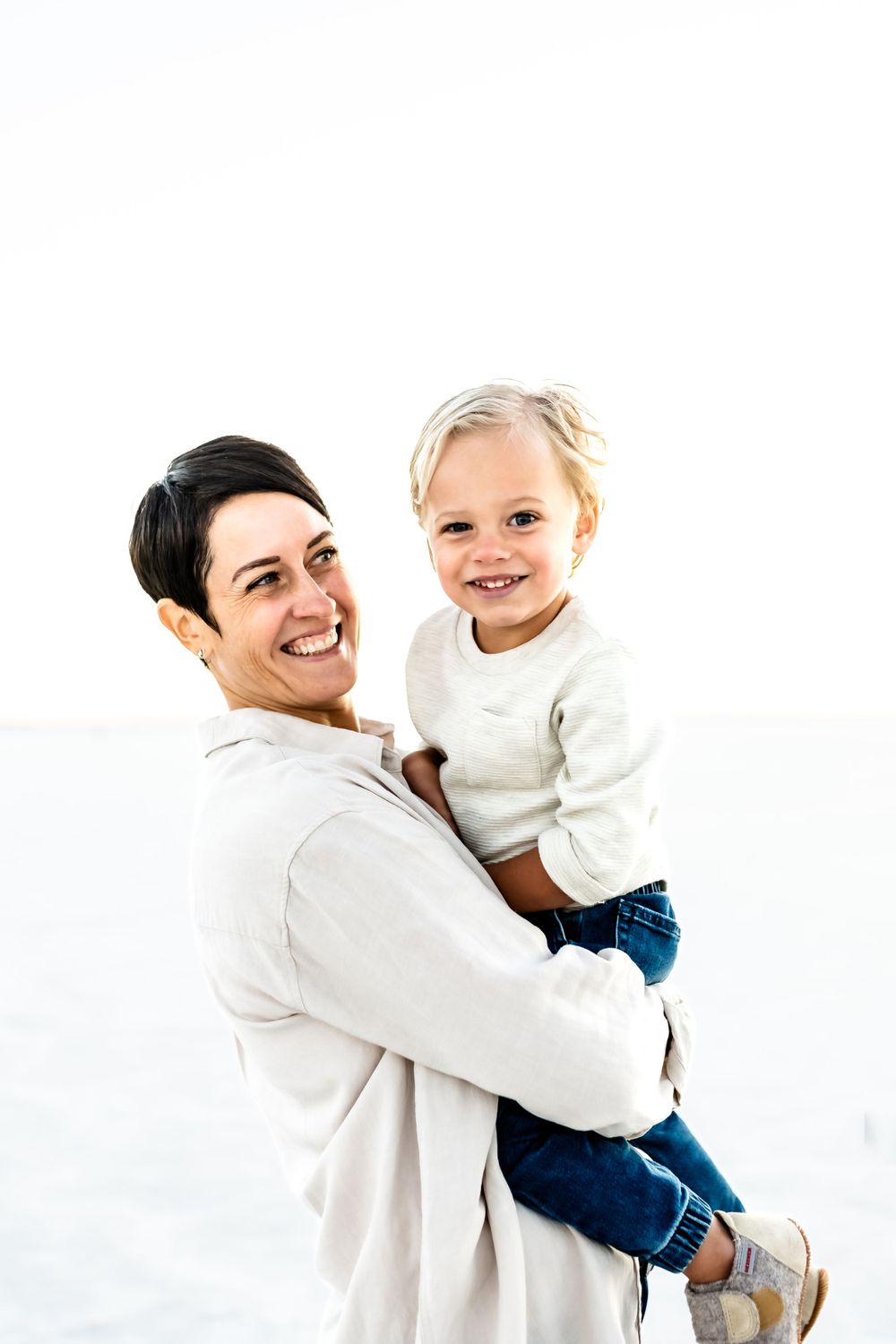 A heartwarming moment captured against a white background in matching cream sweaters.