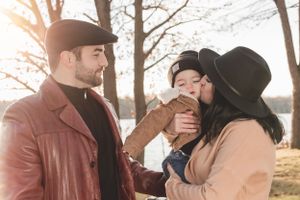 A family shares an intimate moment outdoors during golden hour.