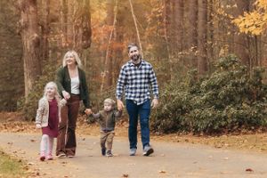 Family enjoying a walk together on a scenic autumn trail surrounded by fall colors.