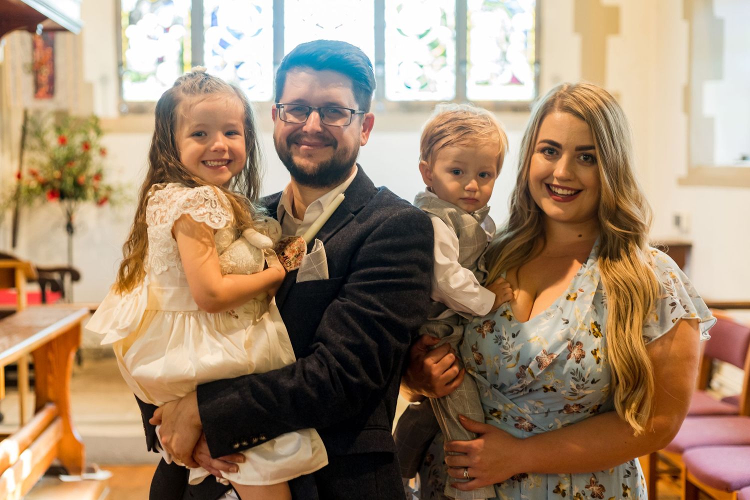 Group celebration in a bright church interior with decorative stained glass windows.