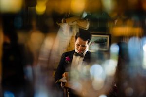A dapper figure in a bowtie and suit captured through a dreamy, bokeh-filled photograph.