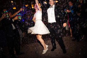 A couple dancing and jumping in celebration with water droplets splashing around them.