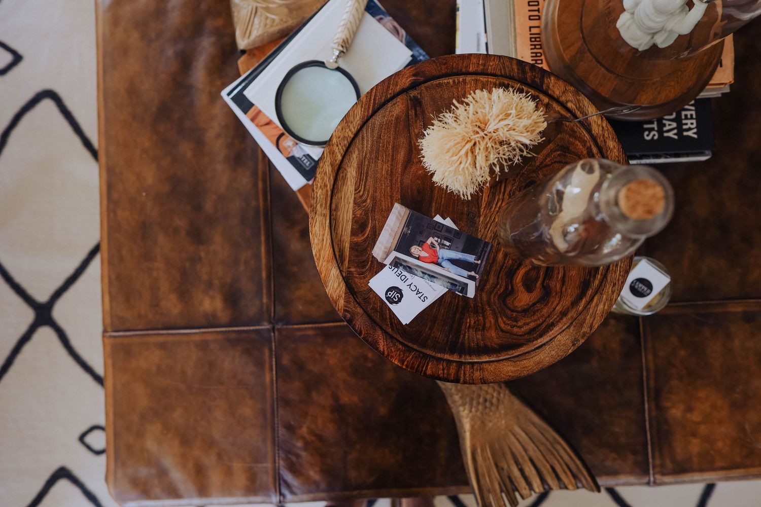 Overhead view of a dark wooden coffee table with decorative items and books arranged on top.