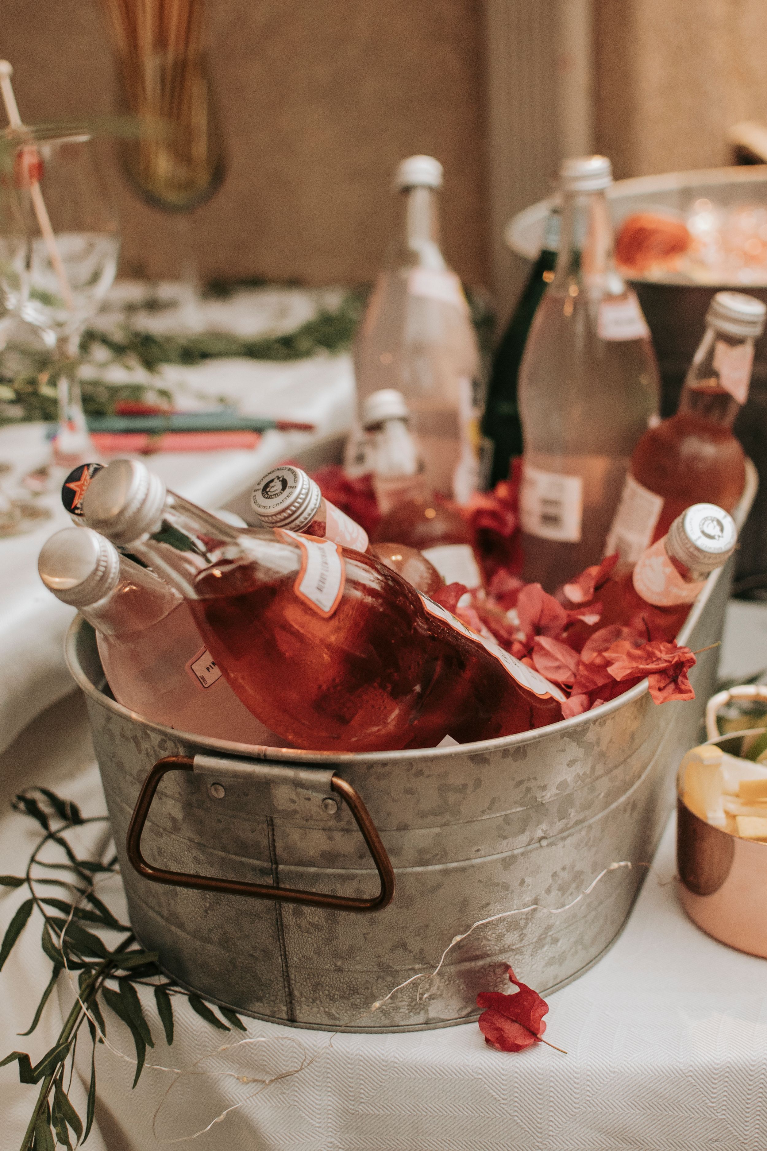 Vintage metal tub filled with pink drinks and bottles on ice.