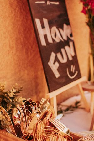 Festive decorative chalkboard signs and pink flowers illuminated by string lights.