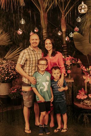 Outdoor family celebration with hanging lights and floral decorations.