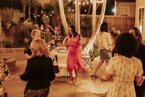Evening dance party on a patio with string lights and palm trees creating a festive atmosphere.