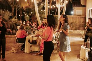 Night party scene with tropical palm decorations and string lights creating warm ambiance.