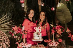 Pink party decor with number 36, hanging glass orbs and floral arrangements.