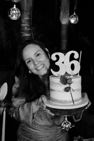 A special birthday celebration with a white two-tier cake decorated with the number 36 under hanging disco balls.