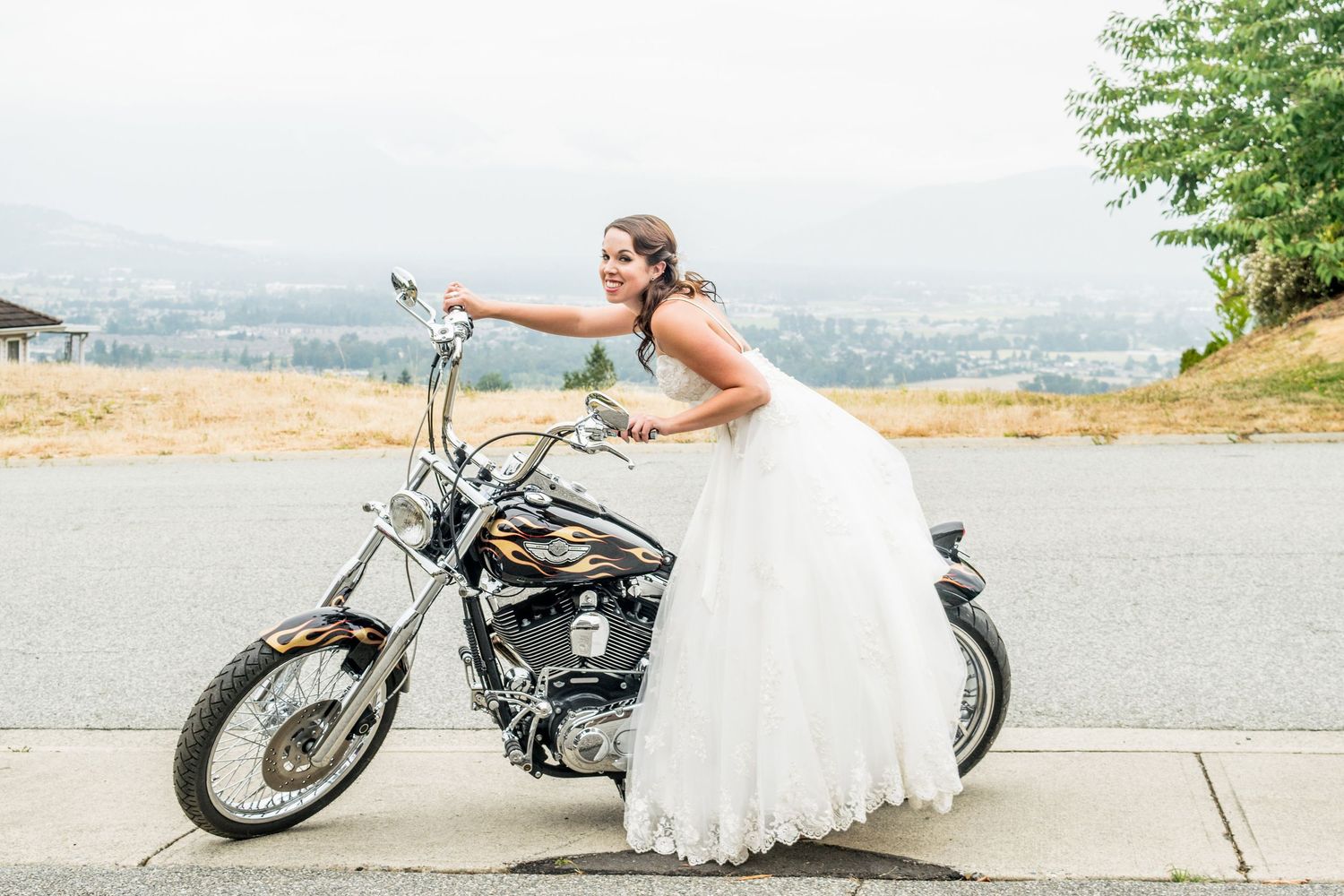 A whimsical bridal portrait featuring a classic motorcycle and flowing white wedding dress.