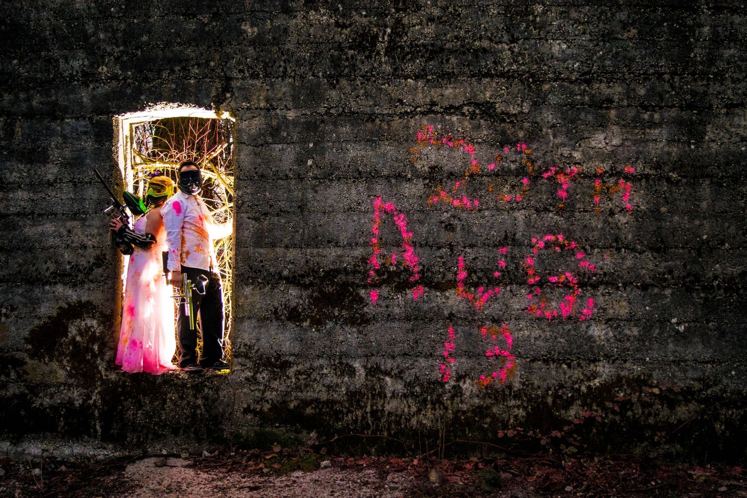 A creative wedding photo through a doorway against a graffiti wall.