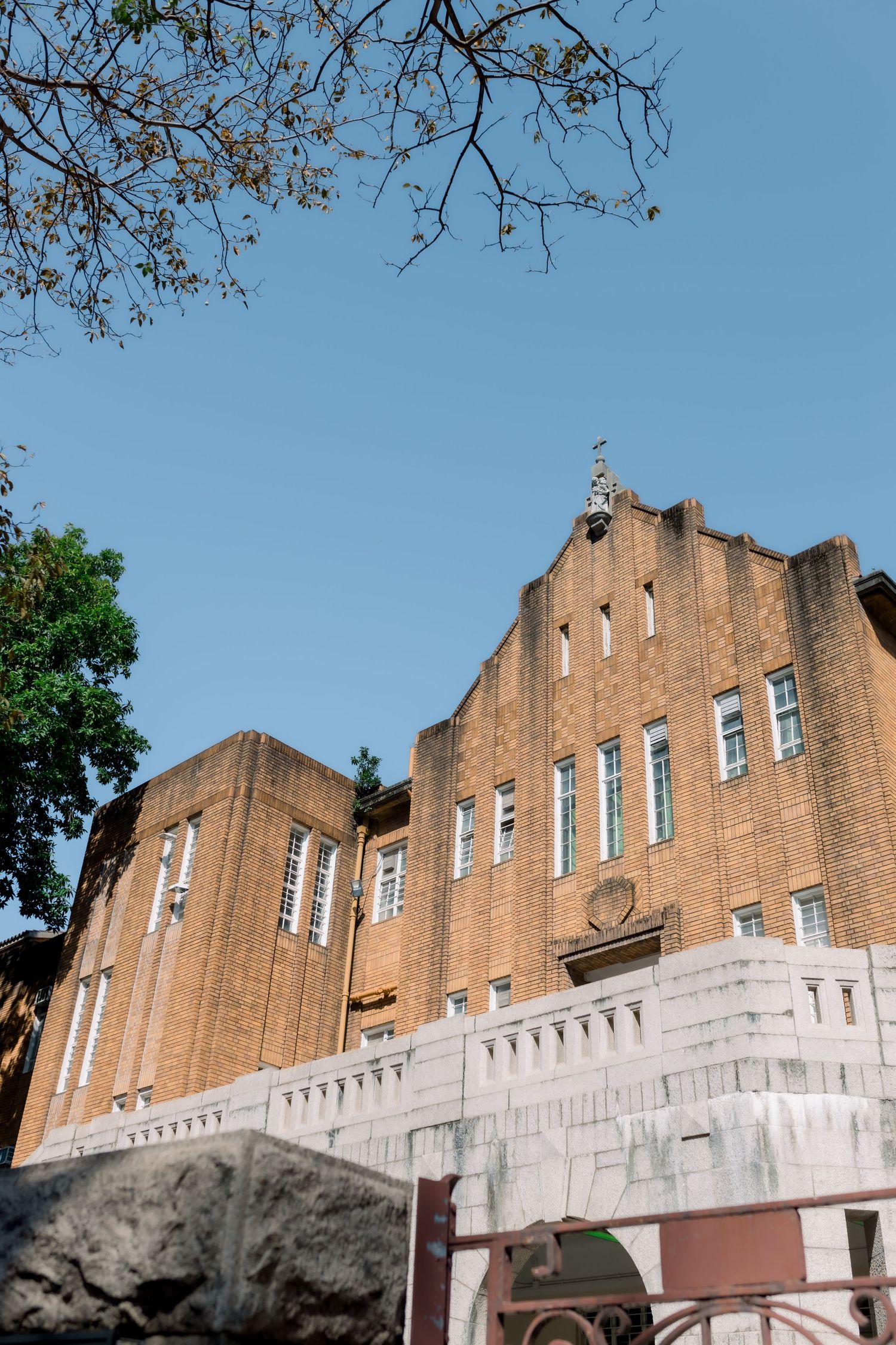 Gothic brick building facade with white trim and sunny blue sky.